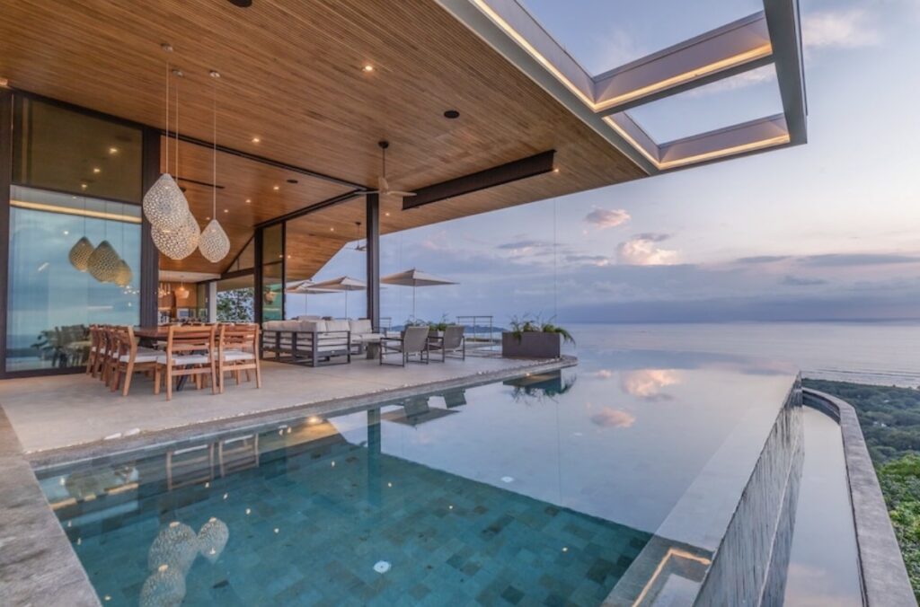 Luxury private villa with infinity pool overlooking the ocean at sunset