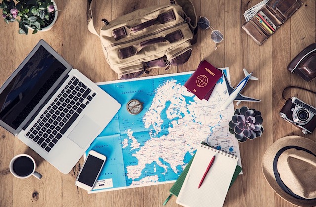 Planning a luxury vacation with calendar and laptop overlooking a tropical setting