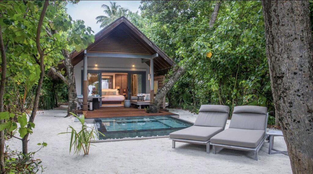 Luxury beach villa in the Maldives with private plunge pool surrounded by tropical greenery 