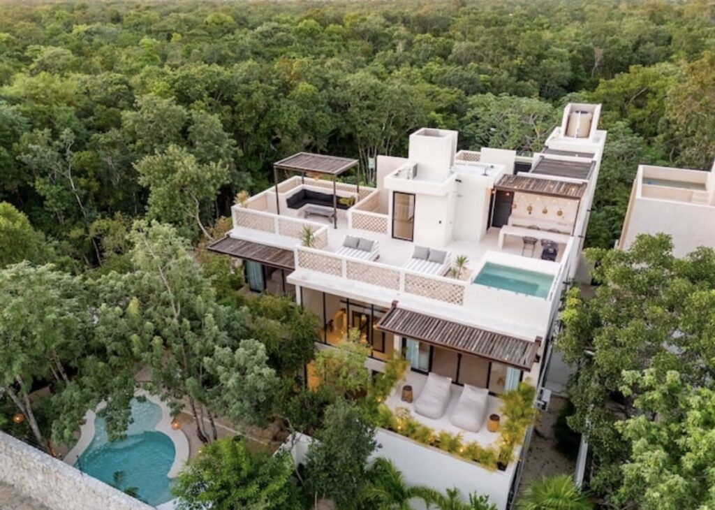 Luxury jungle villa in Tulum with rooftop pool surrounded by tropical greenery.