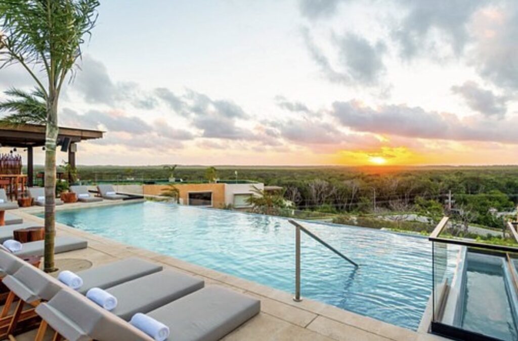 Luxury rooftop villa in Tulum at sunset with ocean view and private terrace.