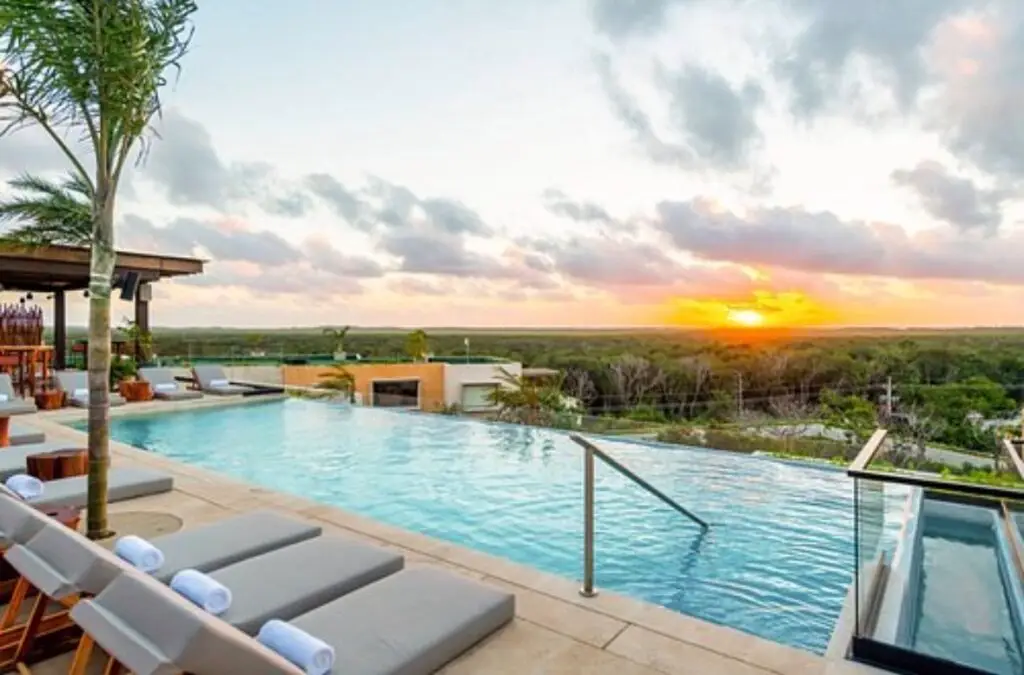 Luxury rooftop villa in Tulum at sunset with ocean view and private terrace.