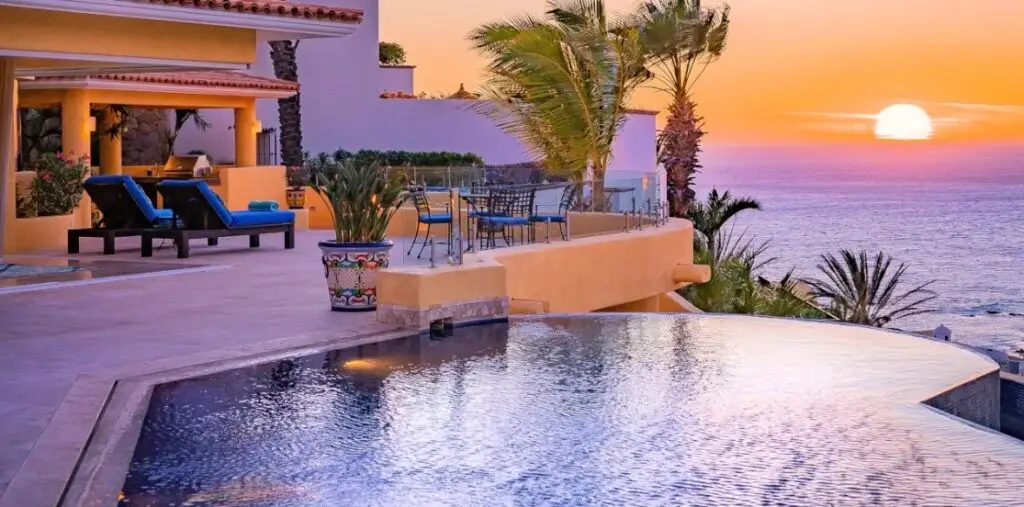 Outdoor dining terrace at a luxury Cabo villa with ocean views and sunset lighting