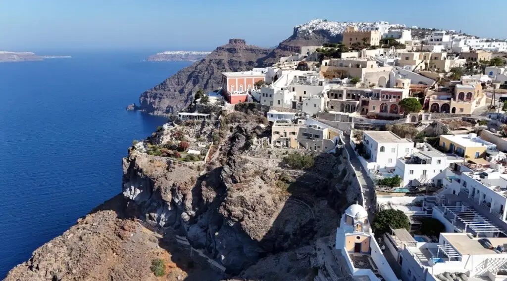 Luxury Santorini villa with infinity pool overlooking the caldera at sunset.
