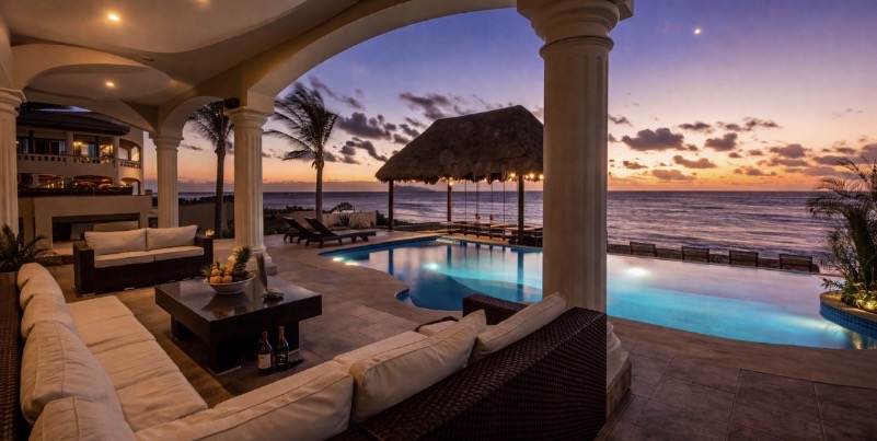 Luxury beachfront villa in Tulum with infinity pool at sunset, ocean view terrace and tropical outdoor living space.